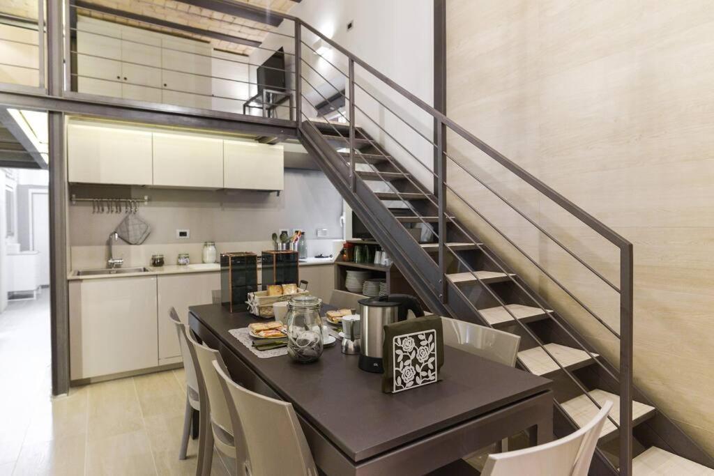 a kitchen with a table with chairs and a staircase at Luxury Home Vittoria in Rome