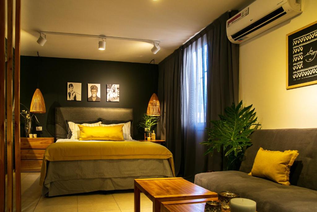 1 dormitorio con 1 cama y 1 sofá en Studio Arístides en Mendoza