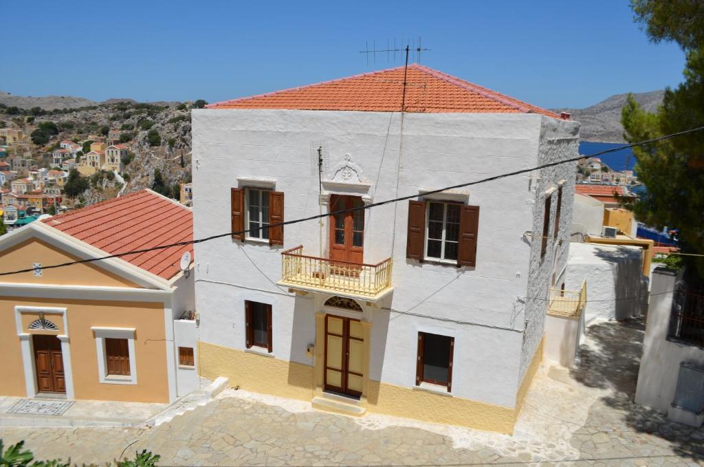 Casa blanca y amarilla con techo rojo en Villa Pavlos en Symi