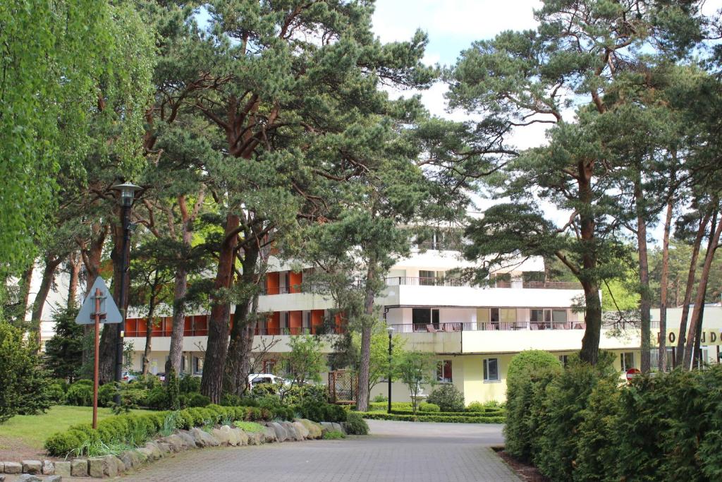 a large building with a tree in front of it at Ośrodek Konferencyjno-Wypoczynkowy "Posejdon" w Ustce in Ustka