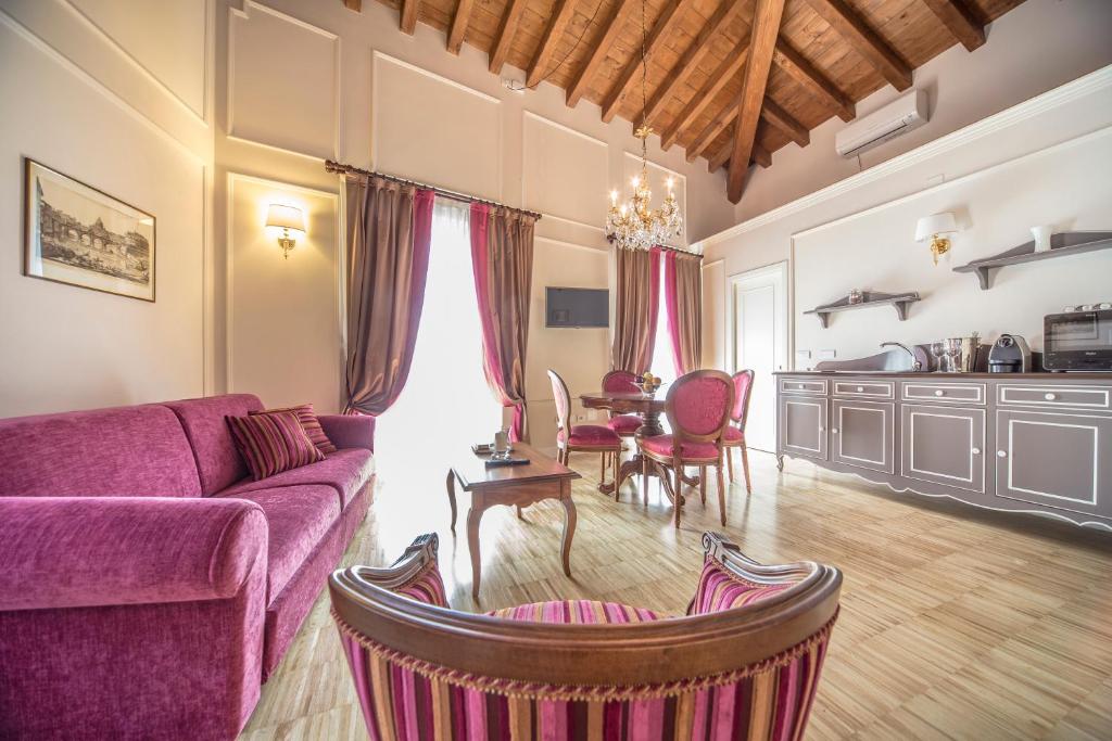 a living room with a purple couch and a table at Lady Capulet Apartments in Verona
