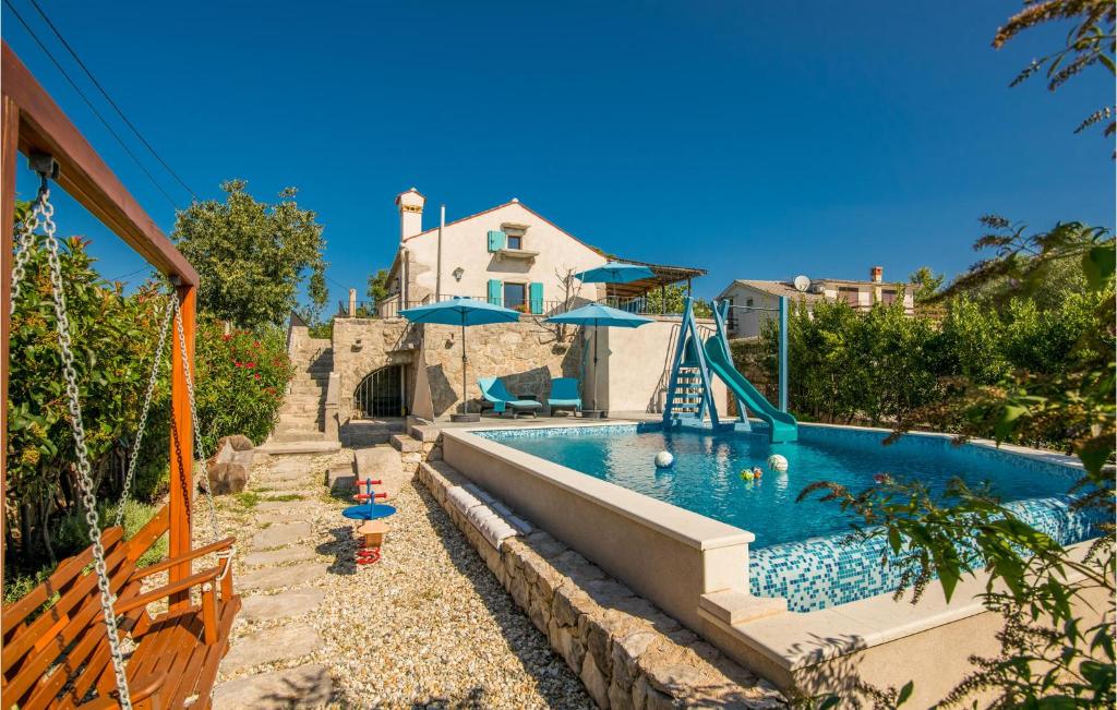 a swimming pool with a slide and a swimming pool at Awesome Home In Kornic With Kitchen in Kornić