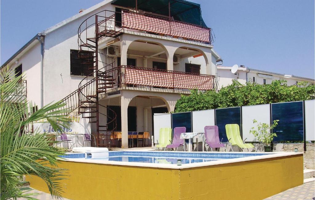 un bâtiment avec une piscine en face d'une maison dans l'établissement Nice Apartment In Okrug Gornji With Wifi, à Trogir