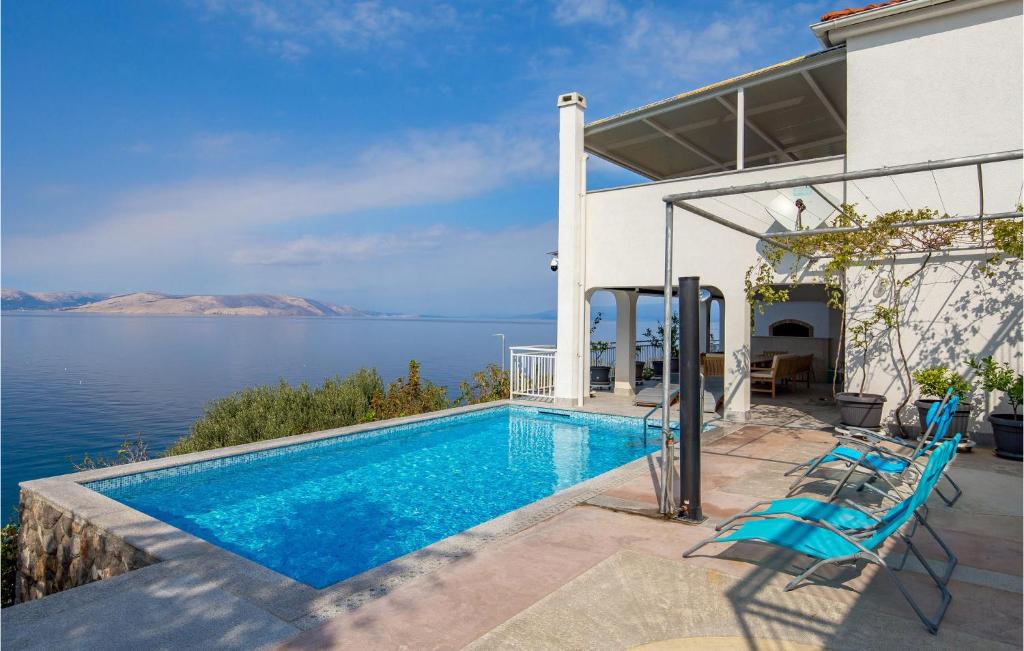een huis met een zwembad met uitzicht op het water bij Pet Friendly Apartment In Sv,juraj With Heated Swimming Pool in Sveti Juraj