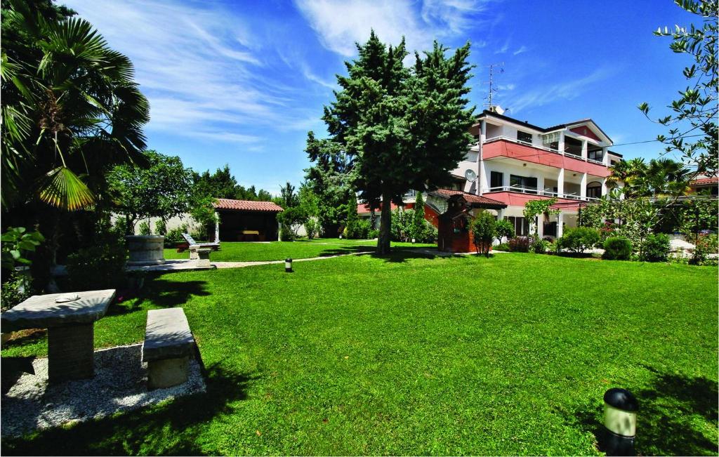 a large yard with a house and a park at 2 Bedroom Amazing Apartment In Savudrija in Zambratija