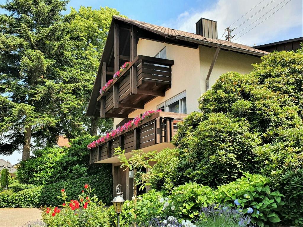 a house with a balcony with flowers on it at Gästehaus Wörner in Durbach