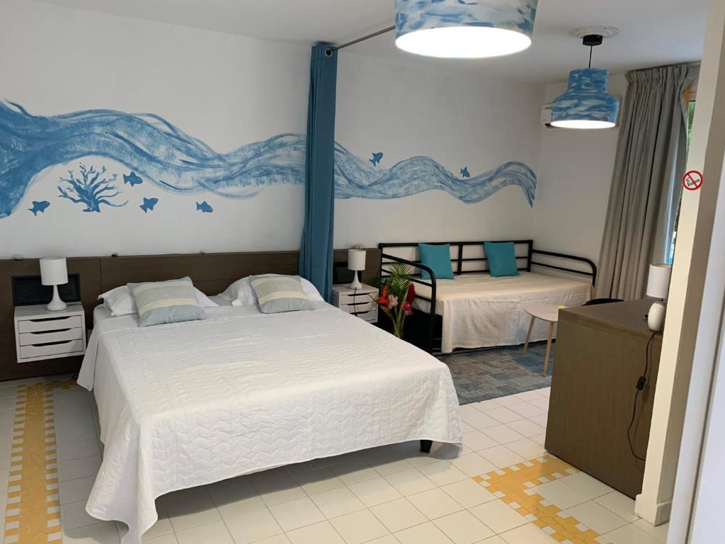sypialnia z dwoma łóżkami i obrazem na ścianie w obiekcie Caribluewave Studio Corail w mieście Saint-François
