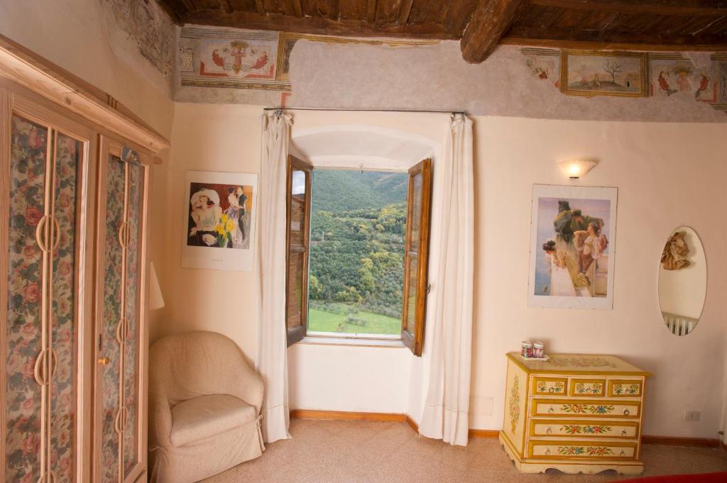 una camera con finestra, sedia e tavolo di La Torretta Historical Home a Casperia