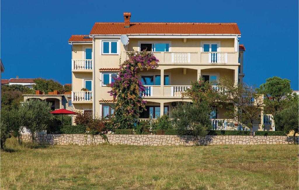 a large building with flowers on a wall at Beautiful Apartment In Povljana in Povljana