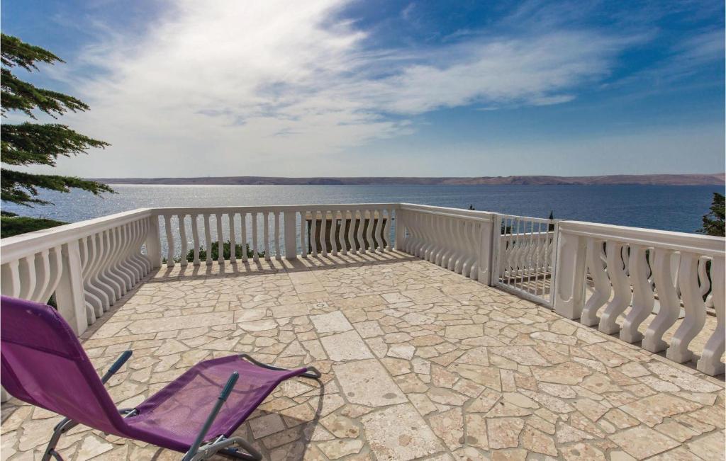 a purple chair sitting on a balcony overlooking the water at Lovely Apartment In Lukovo Sugarje With Kitchen in Lukovo Šugarje