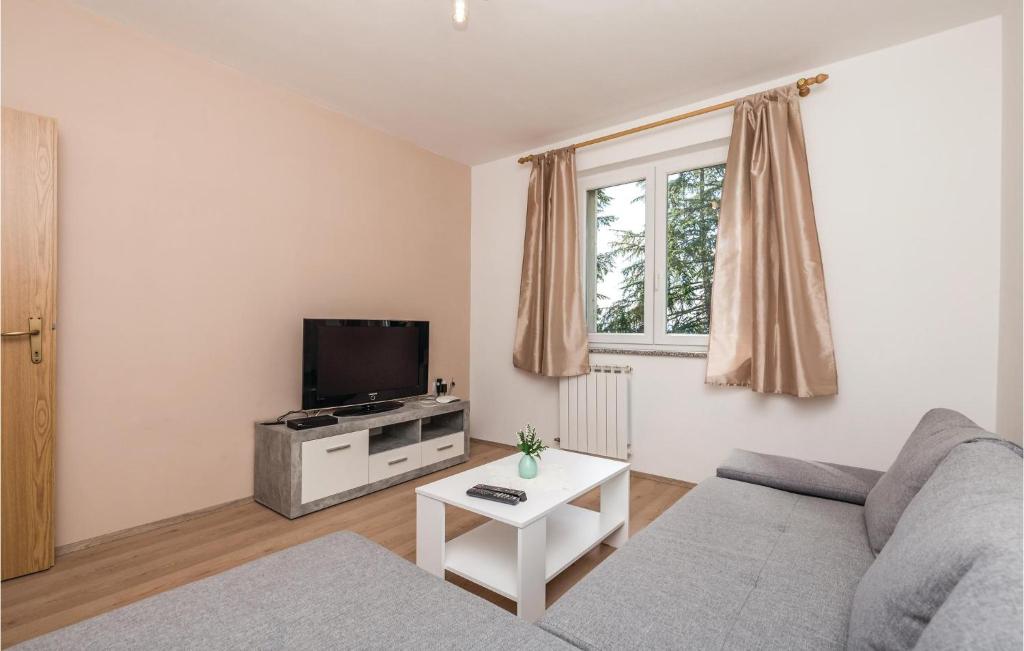 ein Wohnzimmer mit einem Sofa und einem TV in der Unterkunft Stunning Apartment In Lovran With Kitchen in Lovran