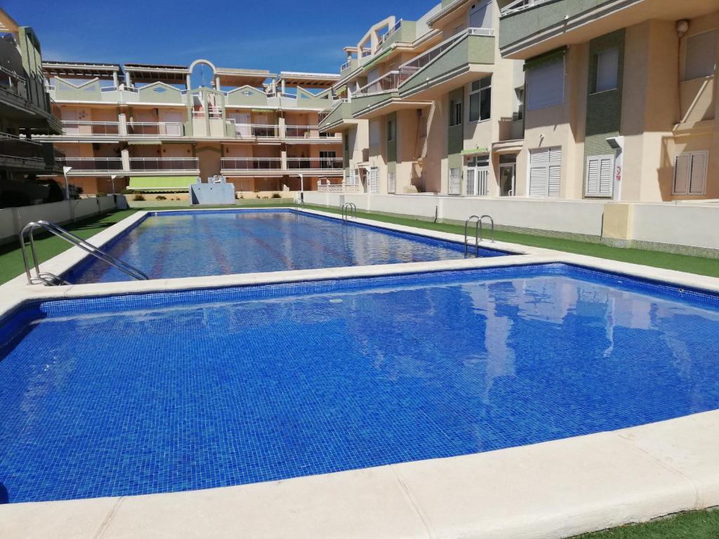 a large swimming pool in front of a building at Delfines III Solo Familias Serviplaya in Playa de Xeraco