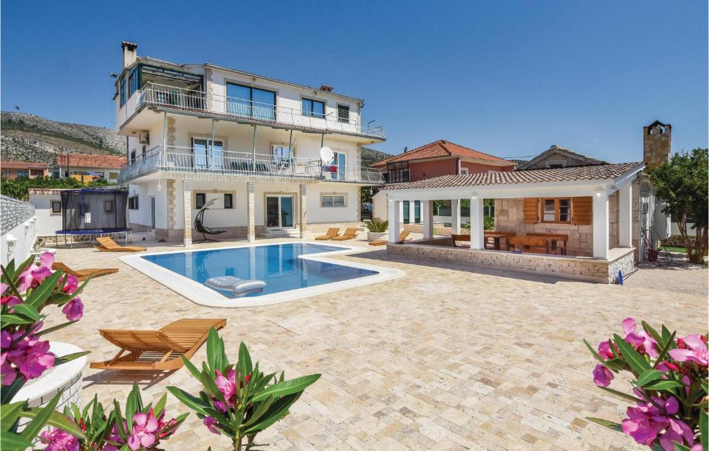ein großes Haus mit Pool im Hof in der Unterkunft Gorgeous Apartment In Seget Donji With Kitchen in Trogir