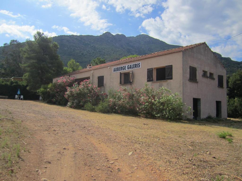 a building on the side of a dirt road at Auberge Galeris in Galeria