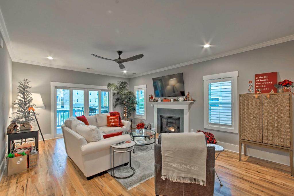 a living room with a white couch and a fireplace at Bright Coastal Abode with Porch and Beach Access! in Carolina Beach