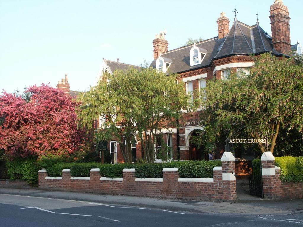 een huis met een bakstenen hek ervoor bij Ascot House in York