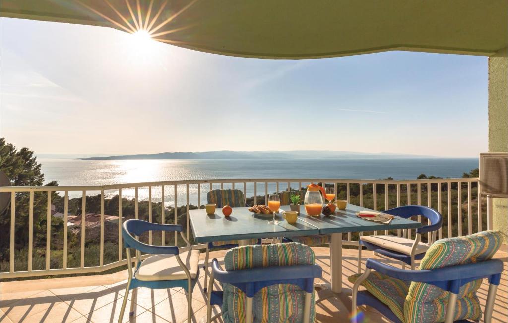 una mesa y sillas en un balcón con vistas al océano en Stunning Apartment In Brela With Wifi, en Brela