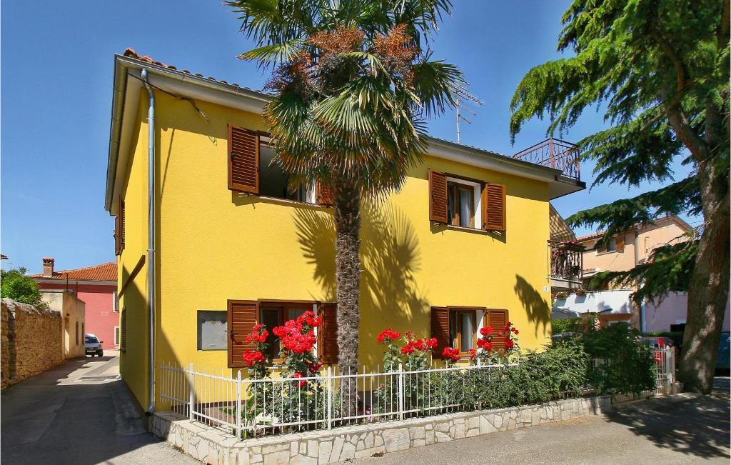 a yellow house with a palm tree in front of it at Awesome Apartment In Novigrad With 2 Bedrooms And Wifi in Novigrad Istria