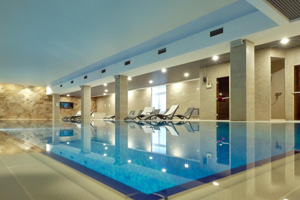 a swimming pool with chairs in a house at Boutique Hotel Tatiana Provence in Zvenigorod