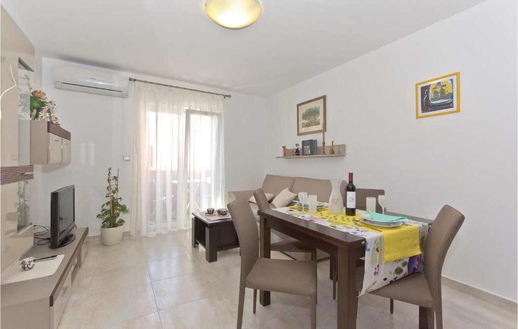a dining room with a table with chairs and a television at Awesome Apartment In Vodnjan With Wifi in Vodnjan