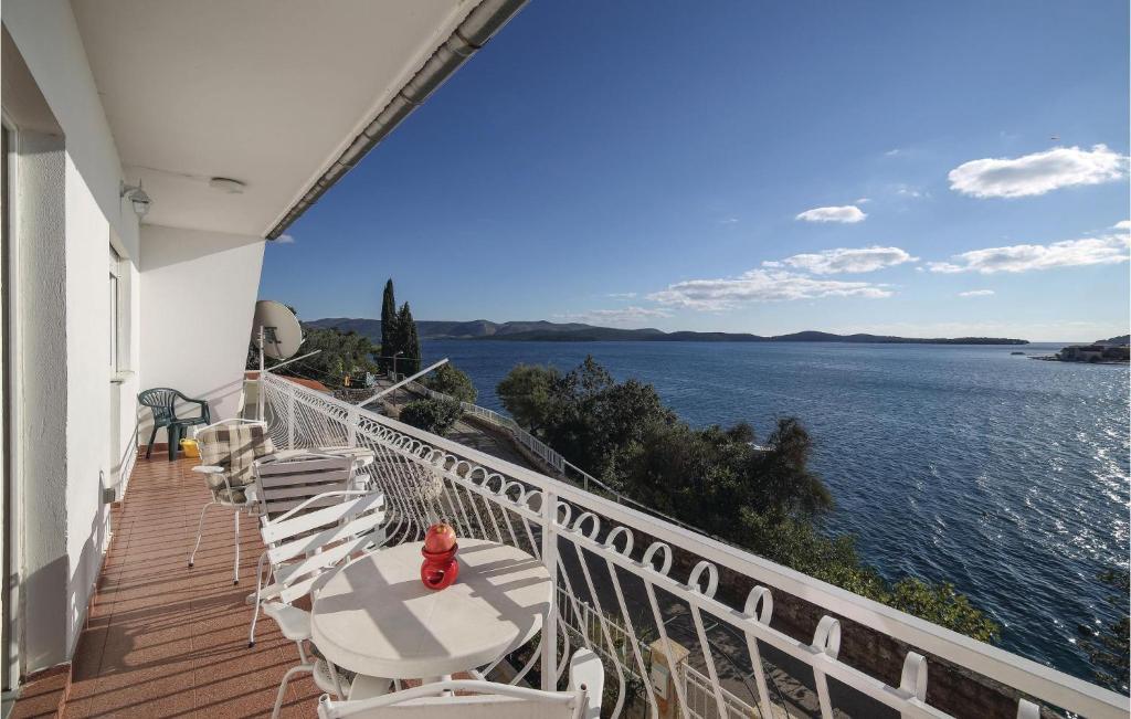 einen Balkon mit weißen Stühlen und Blick auf das Wasser in der Unterkunft Beautiful Apartment In Brodarica With 3 Bedrooms And Wifi in Brodarica
