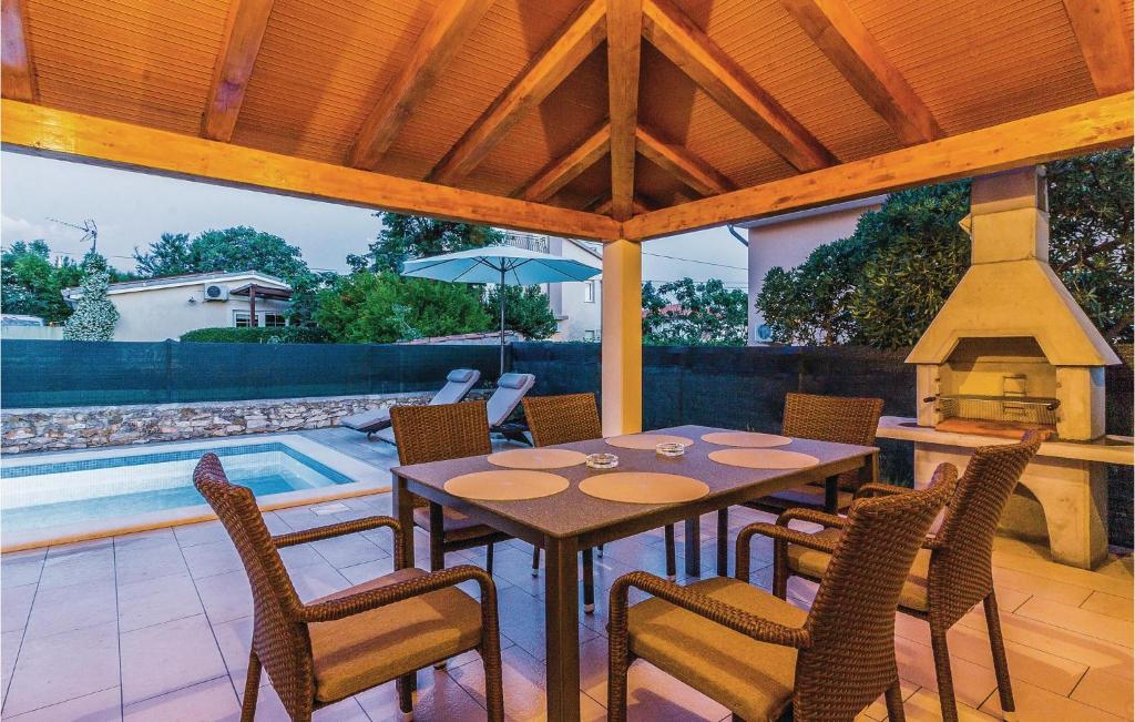 patio ze stołem, krzesłami i kominkiem w obiekcie Holiday Home Medulin Ii w Medulinie