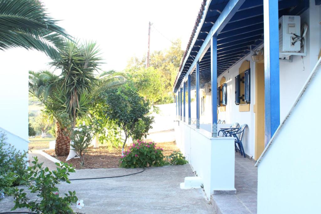 a building with a palm tree in front of it at Theofilos Appartements in Livadi