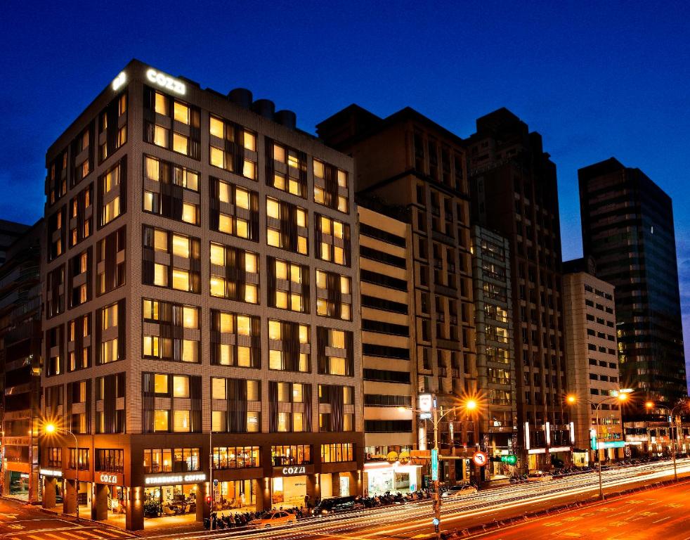 a tall building in a city at night at Hotel COZZI Zhongxiao Taipei in Taipei