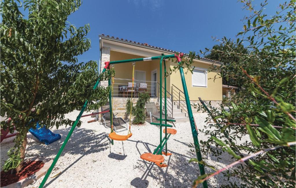a swing set in front of a house at 3 Bedroom Awesome Home In Liznjan in Ližnjan