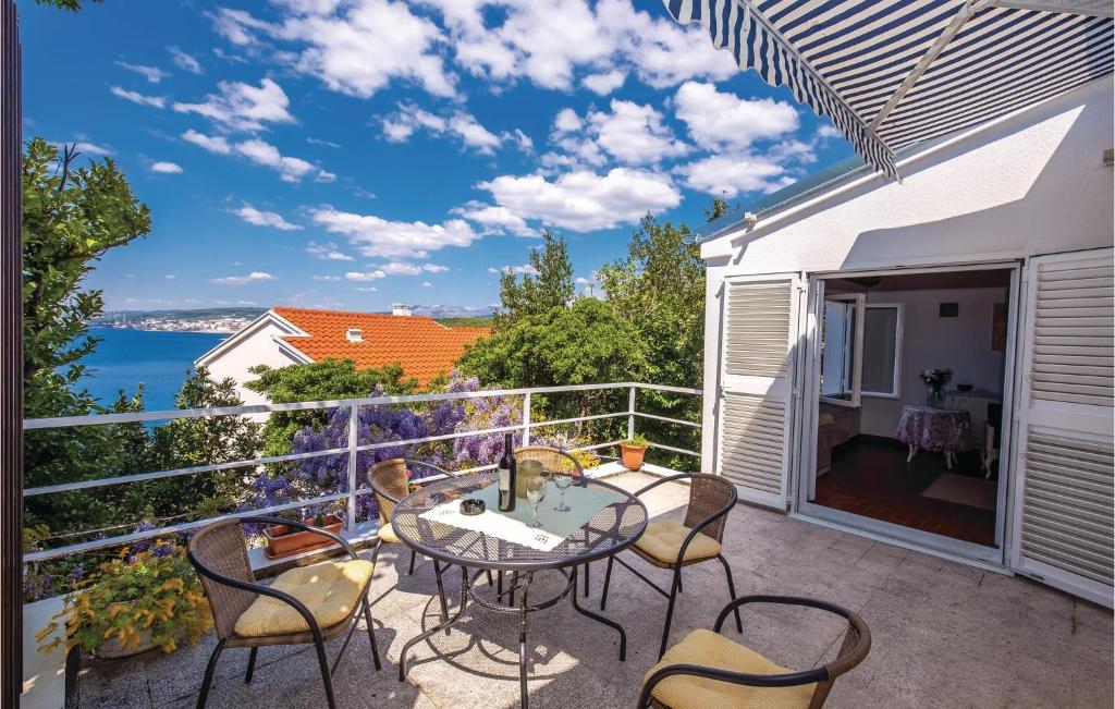 patio ze stołem i krzesłami na balkonie w obiekcie 2 Bedroom Beautiful Home In Kraljevica w mieście Kraljevica