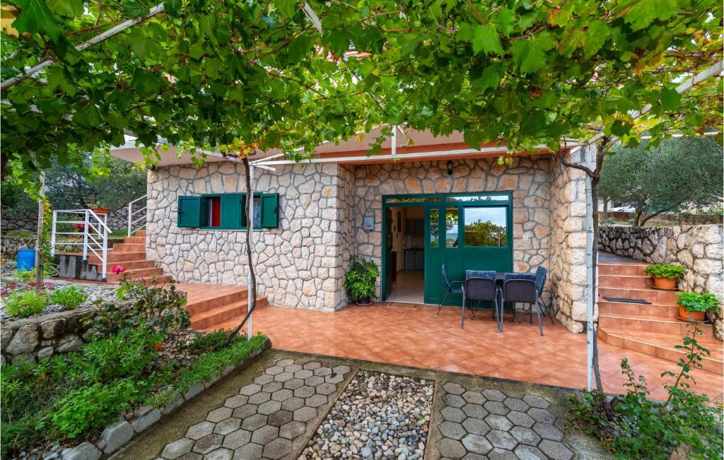 a house with a green door and a patio at Amazing Apartment In Jasenice With Wifi in Jasenice