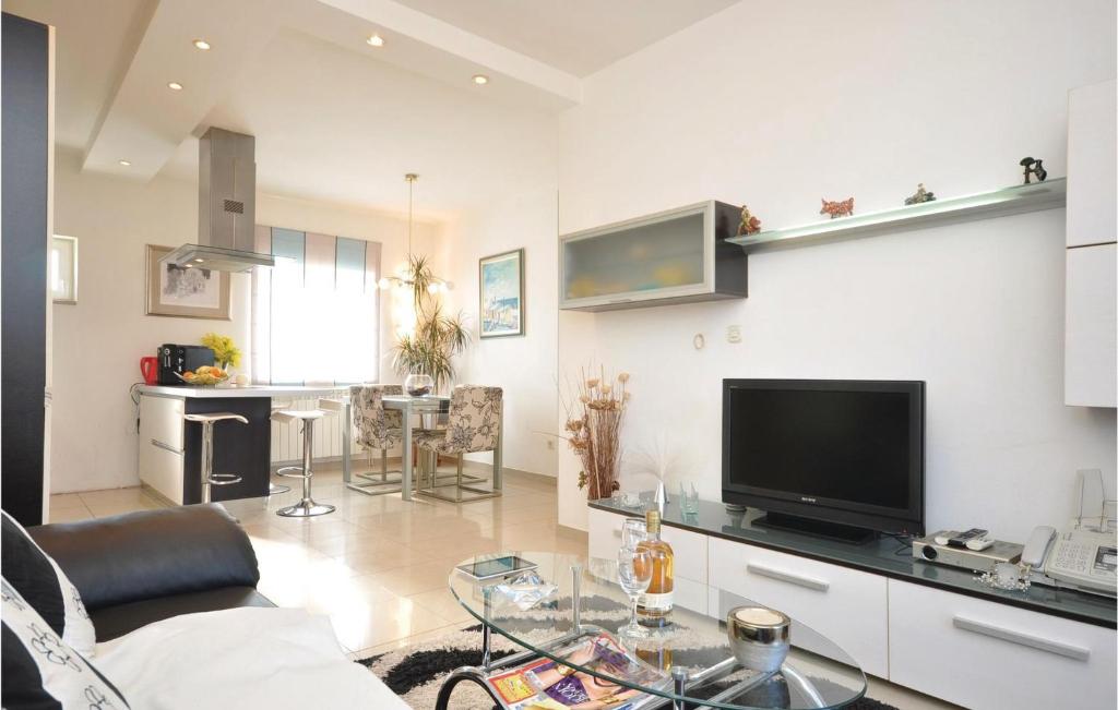 a living room with a couch and a tv and a table at Lovely Apartment In Supetar With Wifi in Supetar