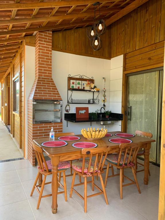 a kitchen with a wooden table with chairs and a stove at Pousada Portal da Praia in Anchieta