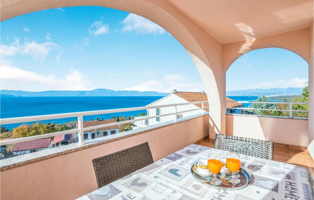 a table on a balcony with a view of the ocean at 2 Bedroom Gorgeous Apartment In Njivice in Njivice
