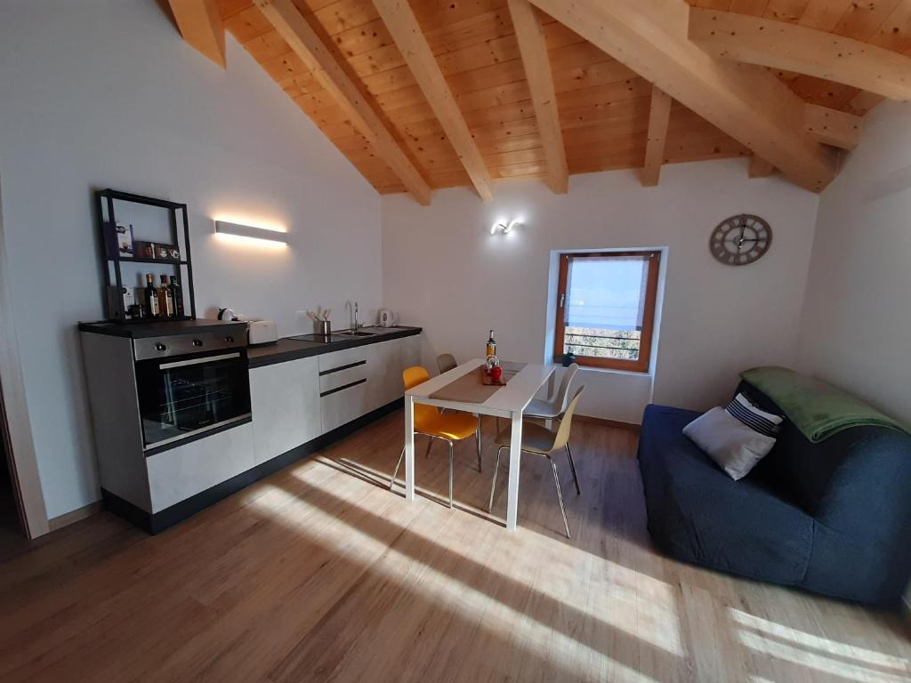 a kitchen and living room with a table and a couch at Appartamenti Piccolo Borgo in Arco