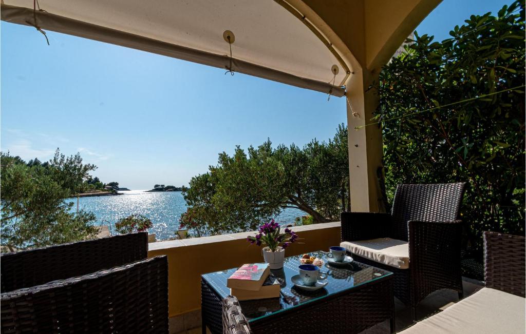 eine Terrasse mit einem Tisch und Stühlen sowie Blick auf das Wasser in der Unterkunft Stunning Home In Vela Luka With Kitchen in Vela Luka