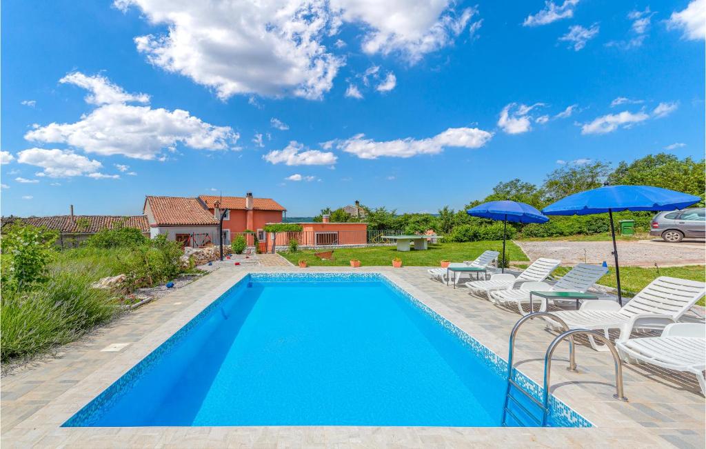 a swimming pool with lawn chairs and umbrellas at Stunning Home In Labin With Wifi in Labin