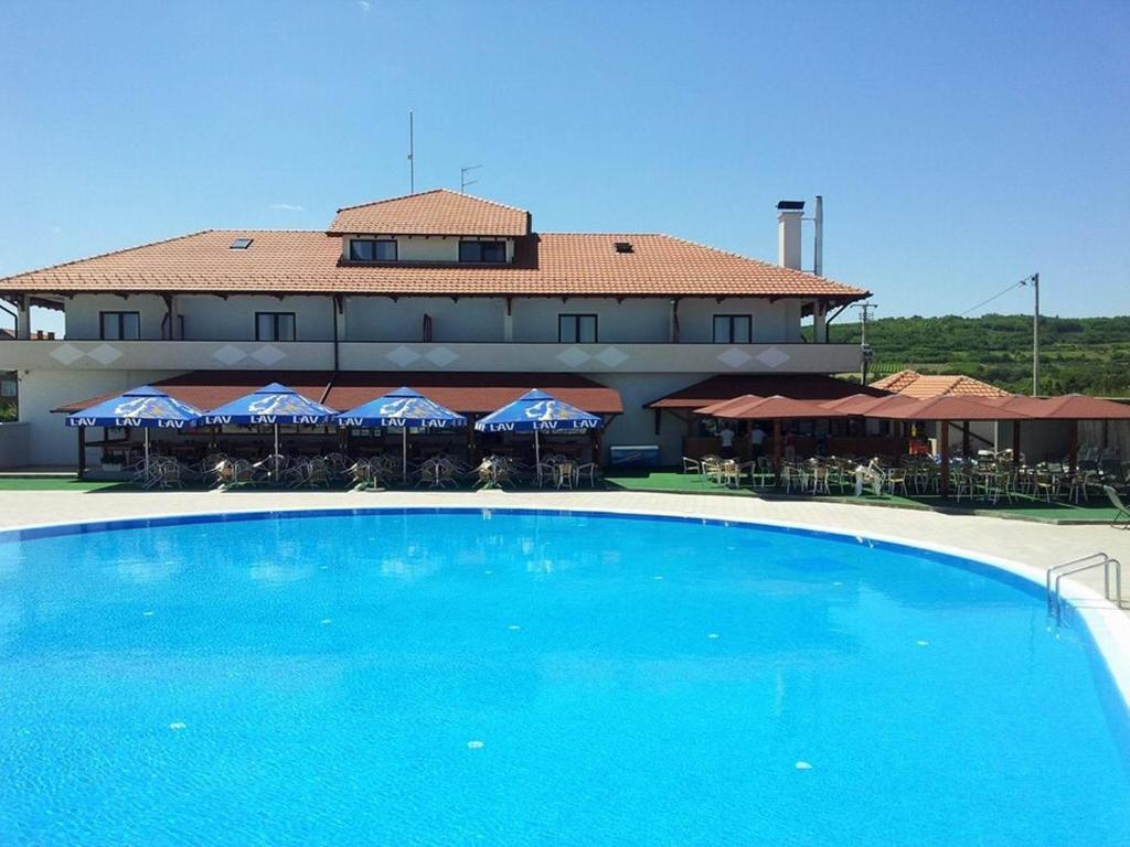 a large blue swimming pool in front of a building at Bazeni Baikal in Topola