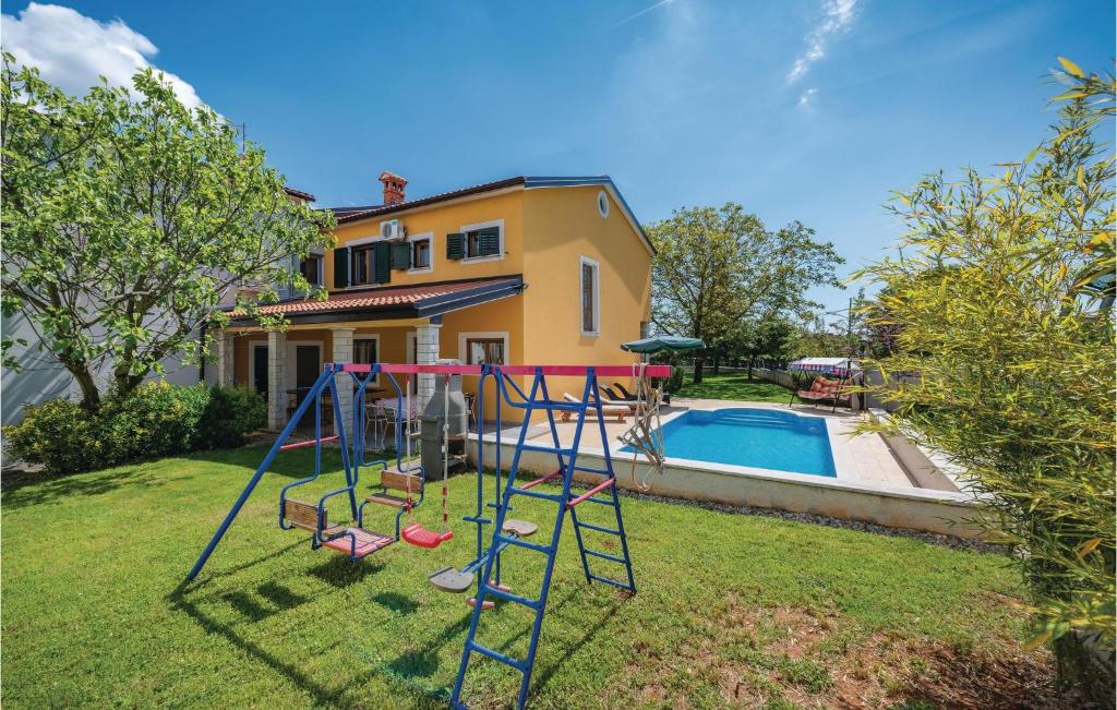 a yard with a playground and a pool at Holiday Home Mlaginje Iii in Žminj