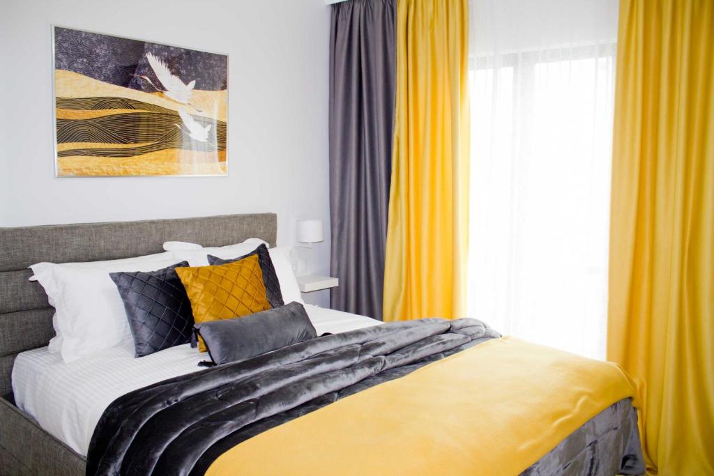 Schlafzimmer mit einem großen Bett und gelben Vorhängen in der Unterkunft Ermis Mini Suite # 3 in Chalkida