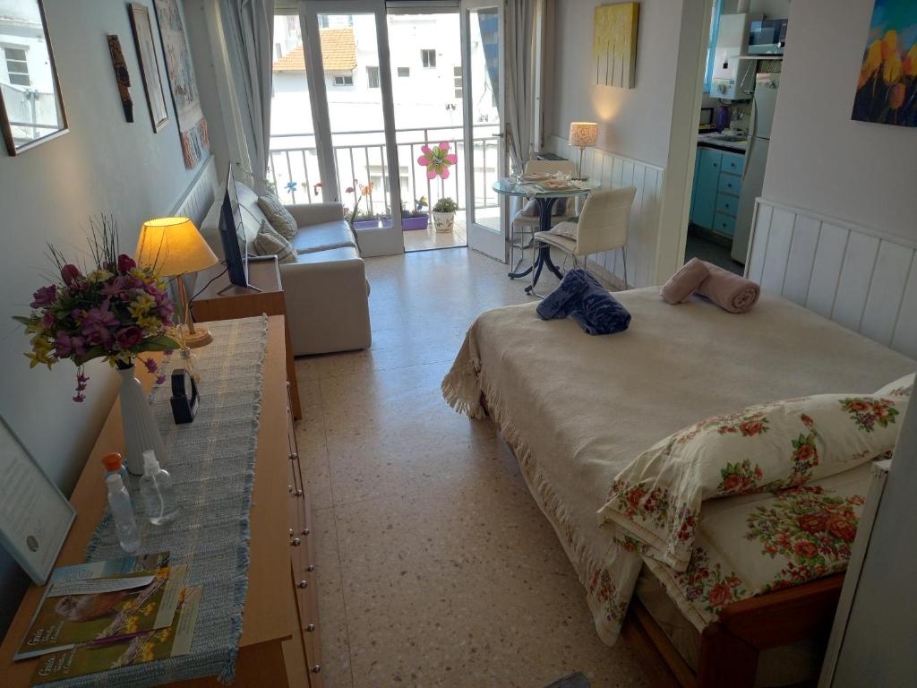 a bedroom with a bed and a table with flowers on it at DESCANSO IDEAL II CABO CORRIENTES in Mar del Plata
