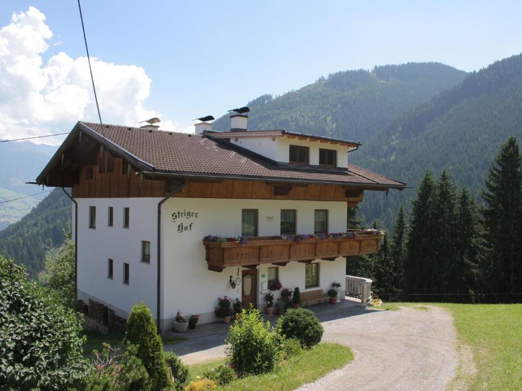 a house on a hill with mountains in the background at Lovely Apartment with Terrace in F genberg in Fügen