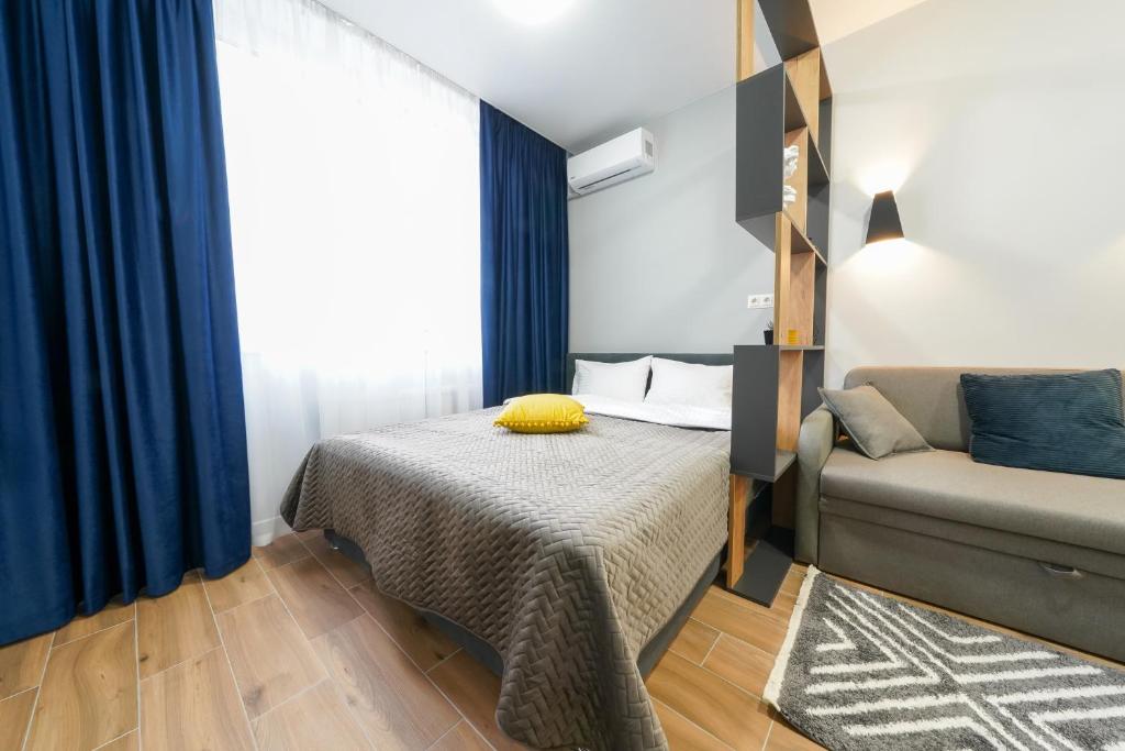 um pequeno quarto com uma cama e um sofá em MYFREEDOM Апартаменти метро Почайна em Kiev