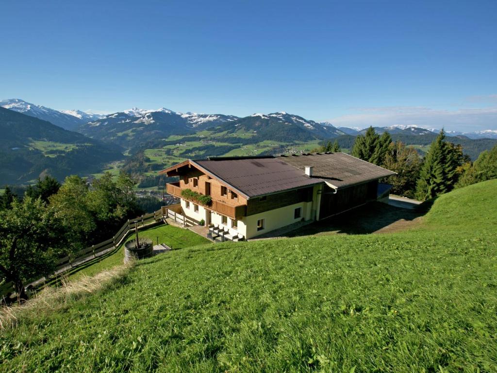 a house on top of a green hill at Chalet in Hopfgarten in Brixental with hot tub in Hopfgarten im Brixental