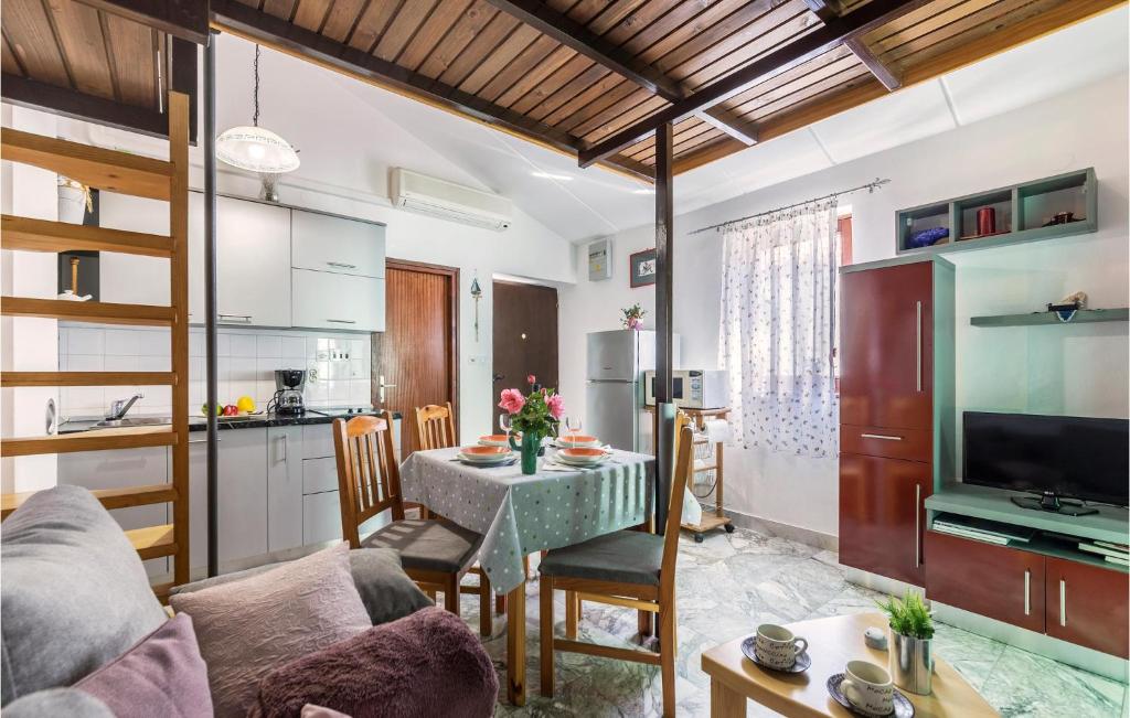 eine Küche und ein Wohnzimmer mit einem Sofa und einem Tisch in der Unterkunft Amazing Apartment In Barbariga With Kitchen in Barbariga