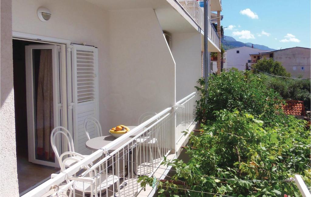a balcony with a table and chairs on a building at Nice Apartment In Makarska in Makarska