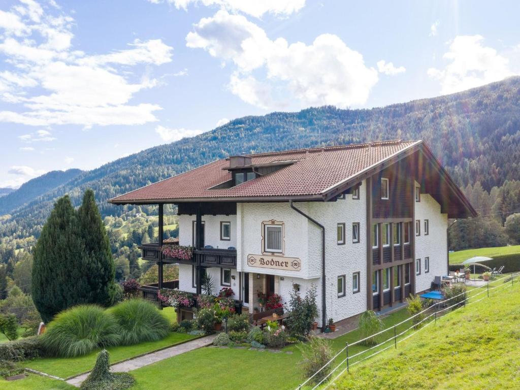 a building on a hill with mountains in the background at Apartment in Afritz near Ski Slopes in Afritz