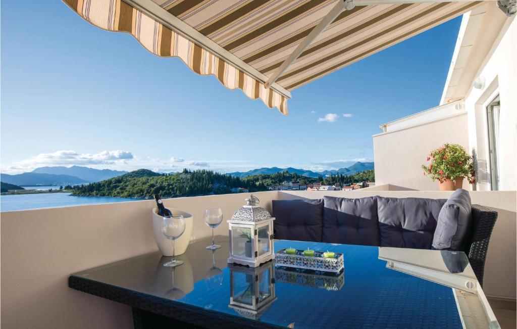 einen Balkon mit einem Tisch und Weingläsern darauf in der Unterkunft Awesome Apartment In Blace With House Sea View in Blace