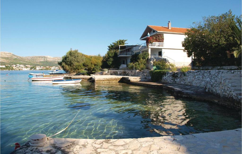 a group of boats in the water next to a building at Awesome Home In Sparadici With 2 Bedrooms And Wifi in Grebaštica