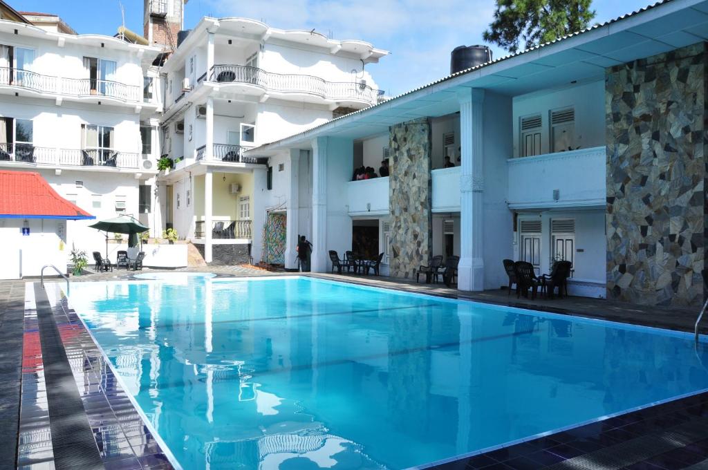 una gran piscina frente a un edificio en Peradeniya Rest House, en Kandy
